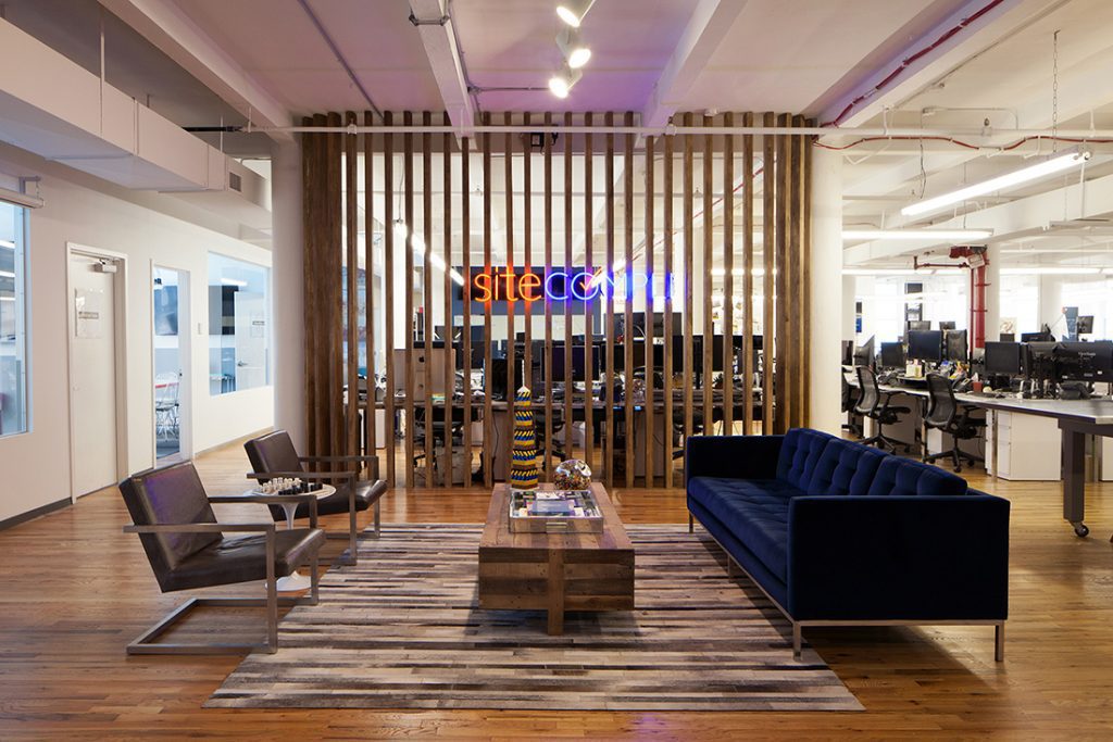 trendy office space with a neon sign and blue furniture